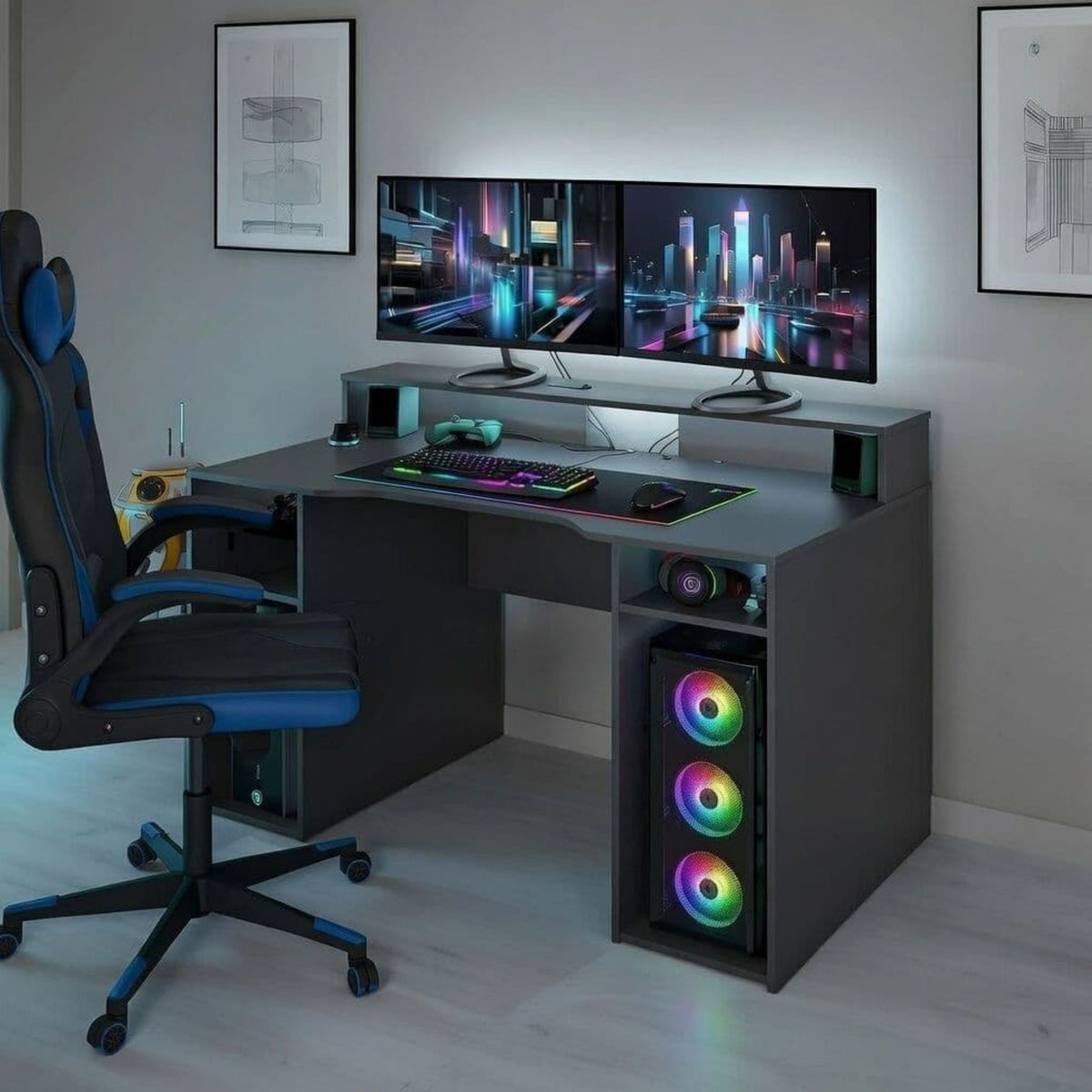 A modern gaming desk setup in a home office environment, featuring a dark gray desk with RGB lighting accents, a black and blue gaming chair, dual monitors showing a neon cityscape, and a computer tower in the desk's open shelf with glowing RGB fans.