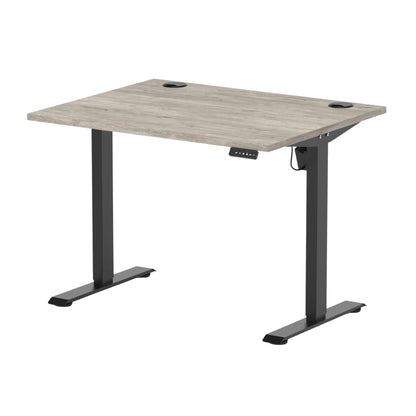An adjustable standing desk with a light gray wood-grain desktop and a black metal T-style frame, shown on a solid white background.