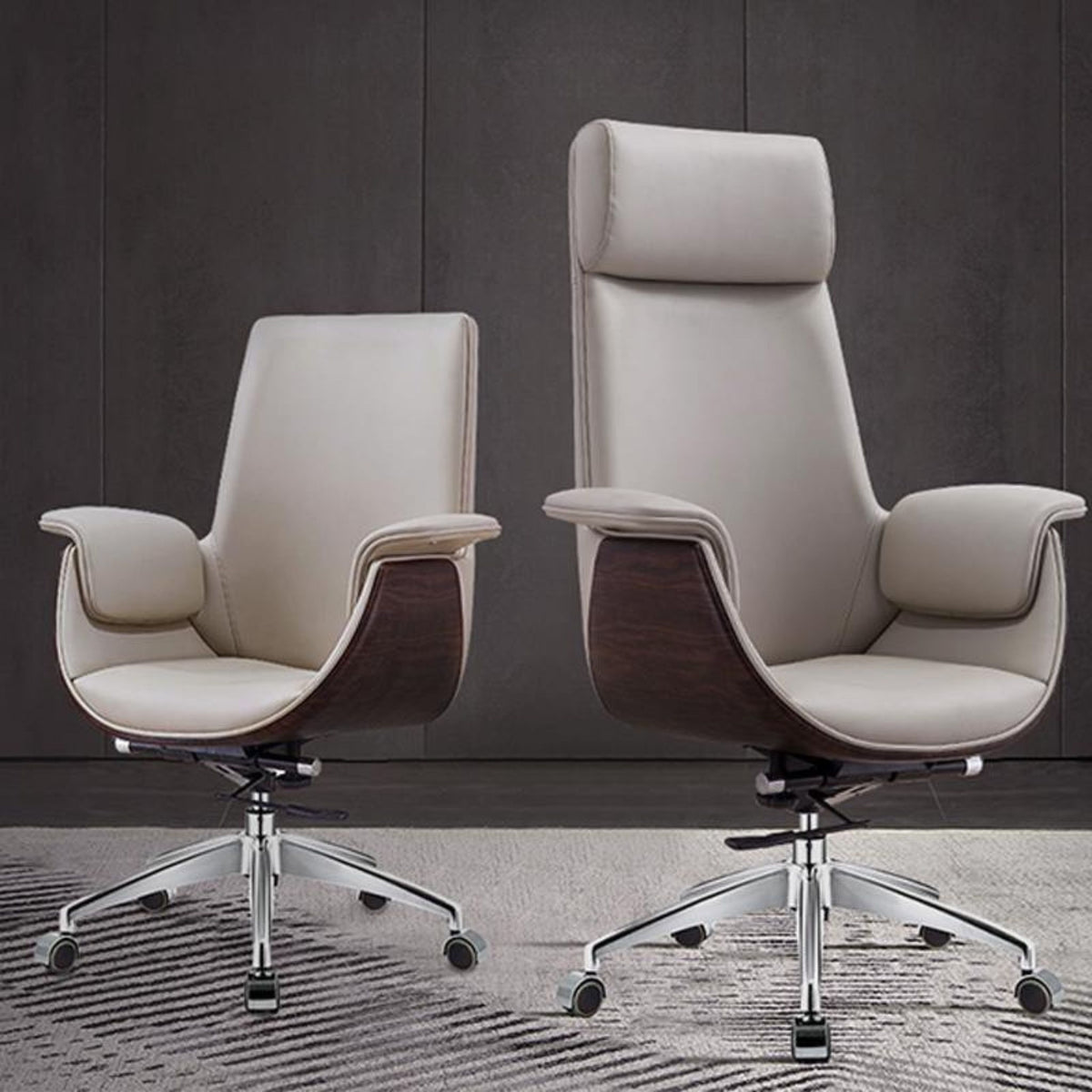 Two modern high-back office chairs with light beige leather upholstery and dark wood-grain side panels, shown on a patterned rug against a dark gray paneled wall.